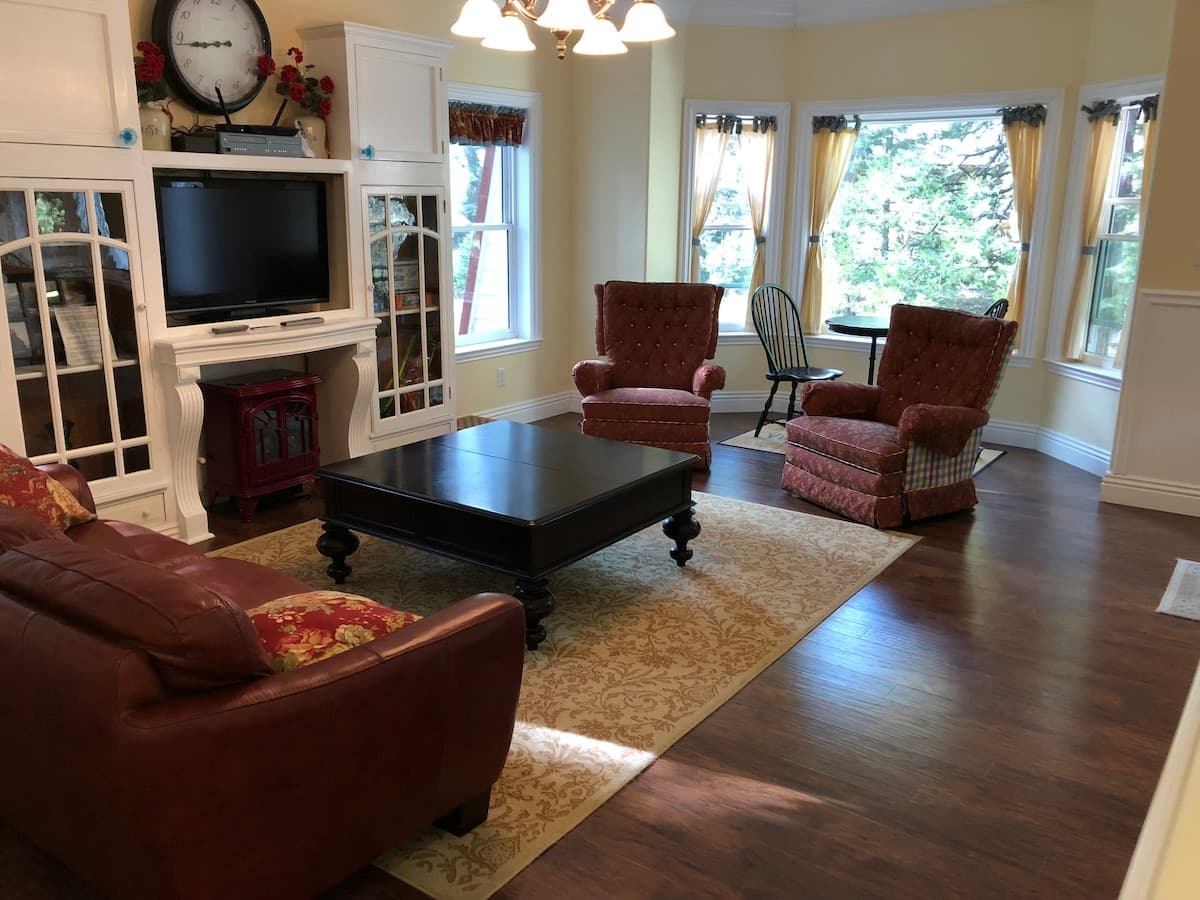 Living room with built-in TV cabinet, leather sofa, and two armchairs